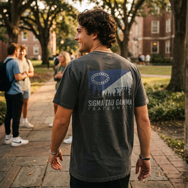 College student wearing fraternity grey t-shirt with colorful flag design on back