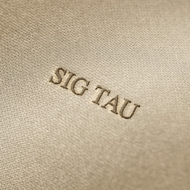 Soft beige fabric close-up showing a smooth, heavyweight knit texture with gentle folds and subtle draping.