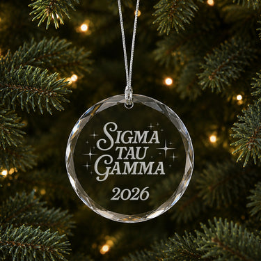 Limited Edition glass Christmas ornament with engraved design hanging on a decorated holiday tree